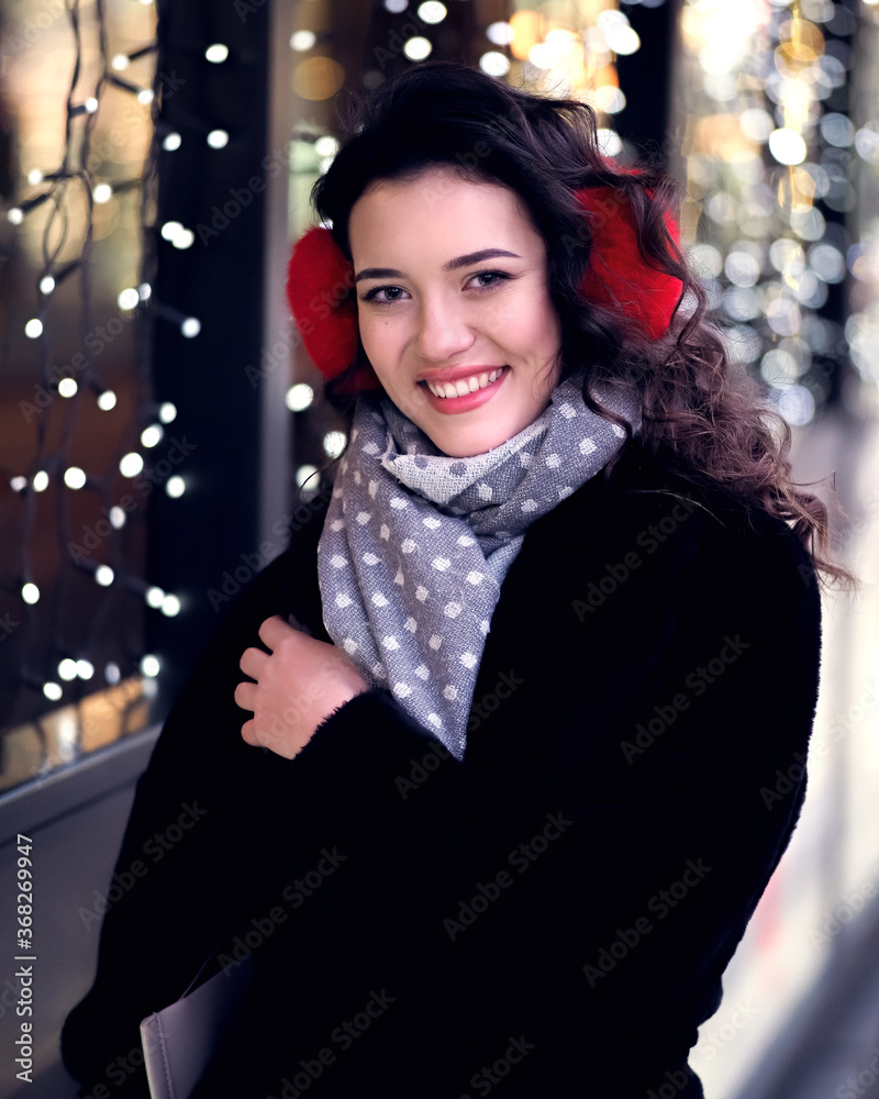 Brunette model posing near lights at the evening at the city