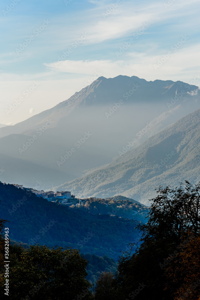 Sochi, Rosa hutor. The mountain view on a sunny autumn day. Contrast colors of landscape, deep blue sky and bright autumn leaves against high mountains peaks