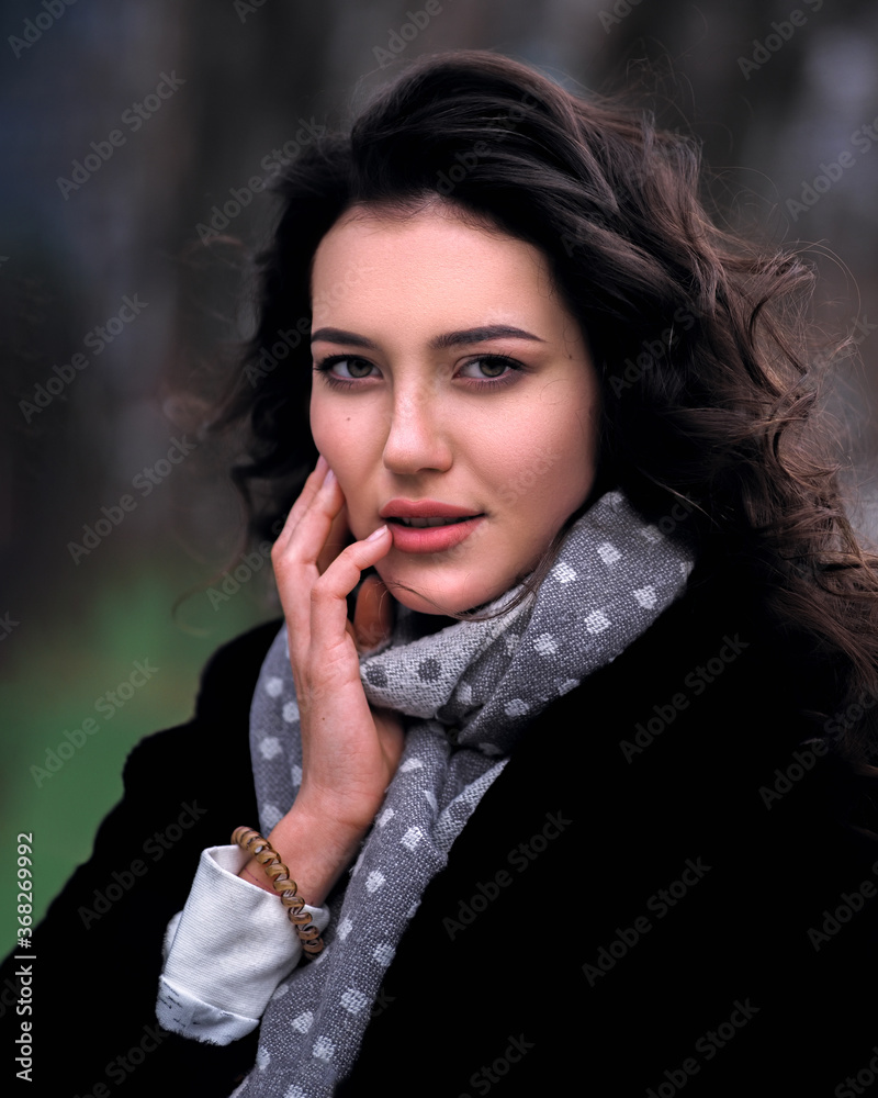 Brunette model with curly hait posing at the city streets