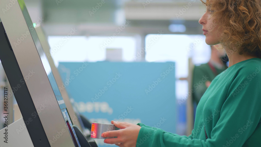 Obraz premium Young woman scanning measuring tape shopping in diy store and buying at self-checkout