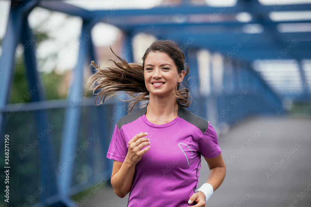 Young female athlete jogging outdoors.