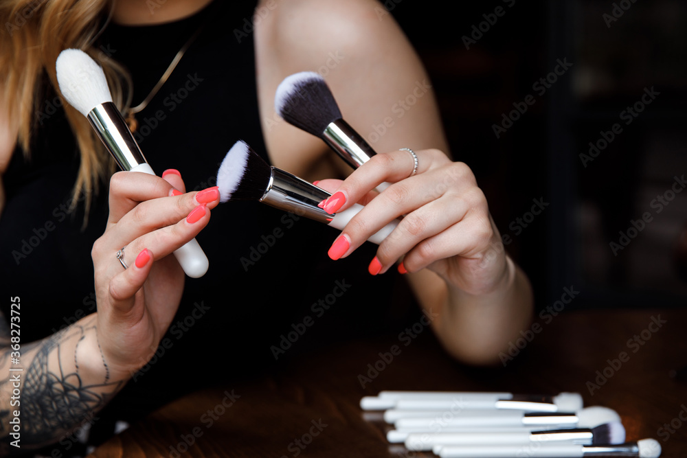 Close up portrait makeup artist. Make up courses. Woman hold makeup brushes on the hands.