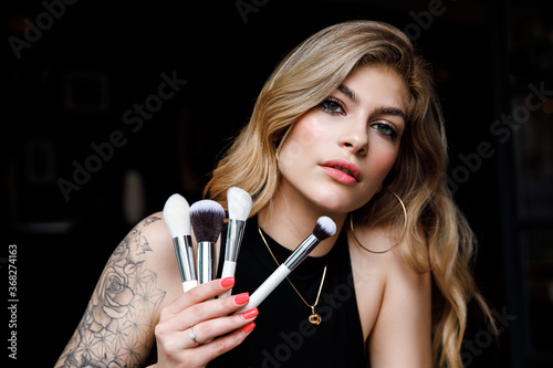 Close up portrait makeup artist. Make up courses. Woman hold makeup brushes on the hands. photo