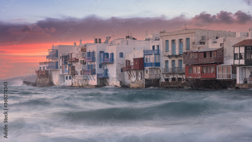 Obraz premium The Little Venice district with old colorful houses by the sea in Mykonos Island at sunset, Cyclades, Greece. Greek landscape (100 matches), Travel and tourism concept.