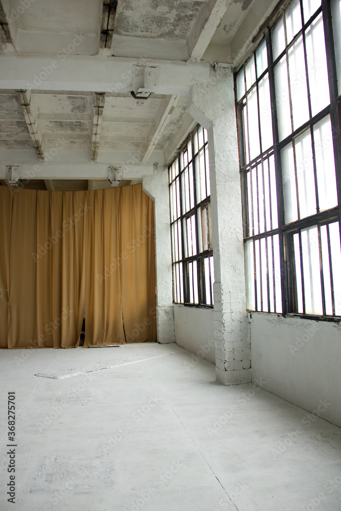 industrial white hall with huge windows and brown cloth on one of the wall background