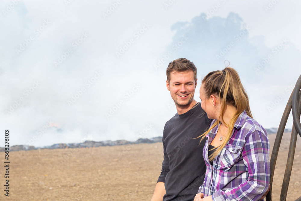 Young couple looking at each other outdoors with smoky background Young couple looking at each other outdoors with smoky background