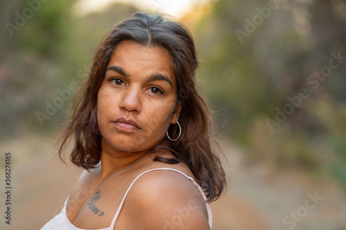 young woman looking at camera with blurry background photo