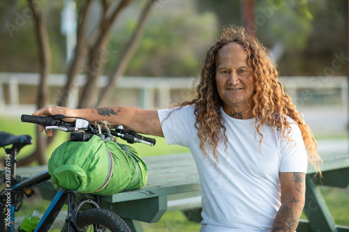 traveller sitting with bike in park