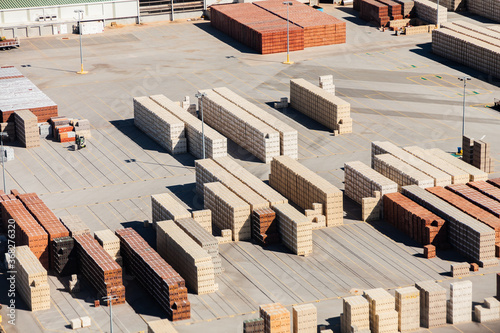 Piles of bricks in store area in industrial area of city