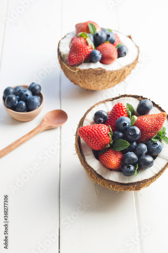 Halved coconuts filled with berries photo