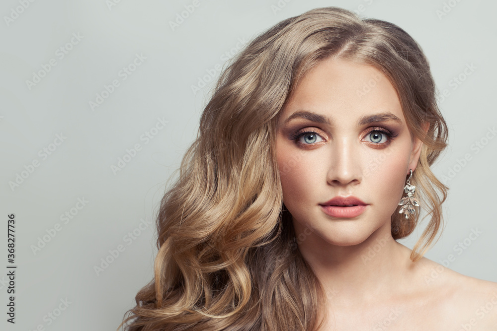 Young healthy woman with long blonde curly hair on white Young healthy woman with long blonde curly hair on white