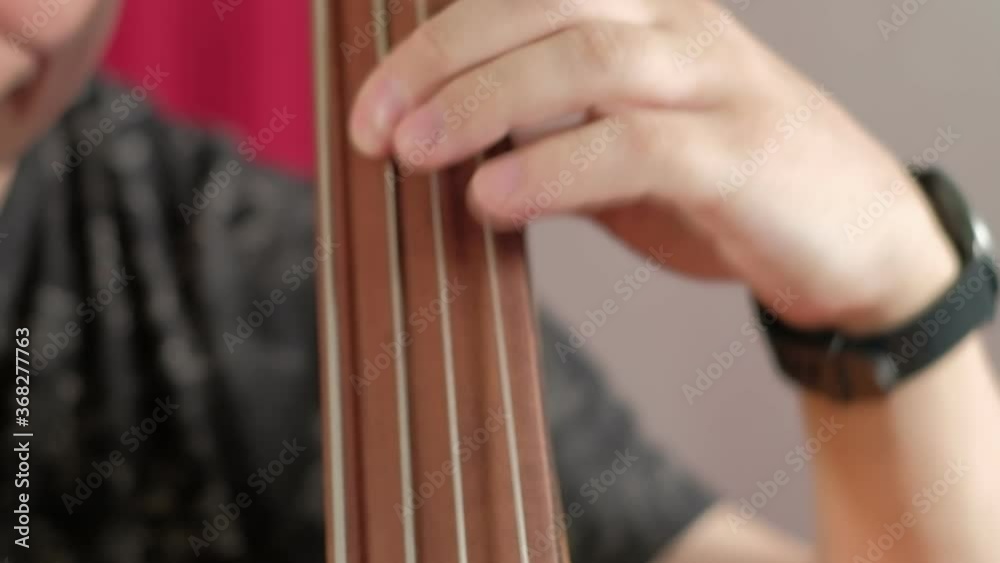 Men is playing double bass with bow. close up. Man musician performing bow technique. contrabass rhythm at classical concert. Acoustic bass instrument Men is playing double bass with bow. close up. Man musician performing bow technique. contrabass rhythm at classical concert. Acoustic bass instrument