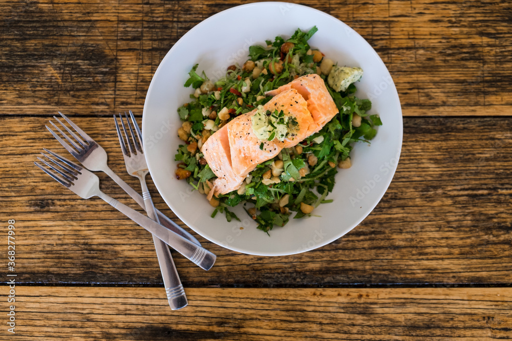 Fresh cooked salmon on a salad with greens and macadamias Fresh cooked salmon on a salad with greens and macadamias