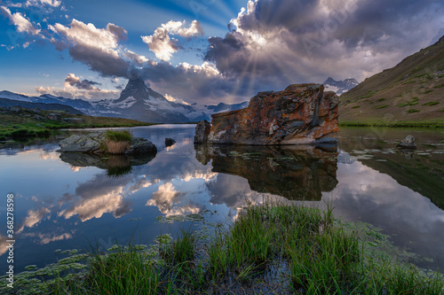 Sunny evening view of Stellisee lake with Matterhorn and rainbow and reflection into the lake. Captivating summer scene of Swiss Alps, Zermatt resort location, Switzerland, Europe. Travel concept.