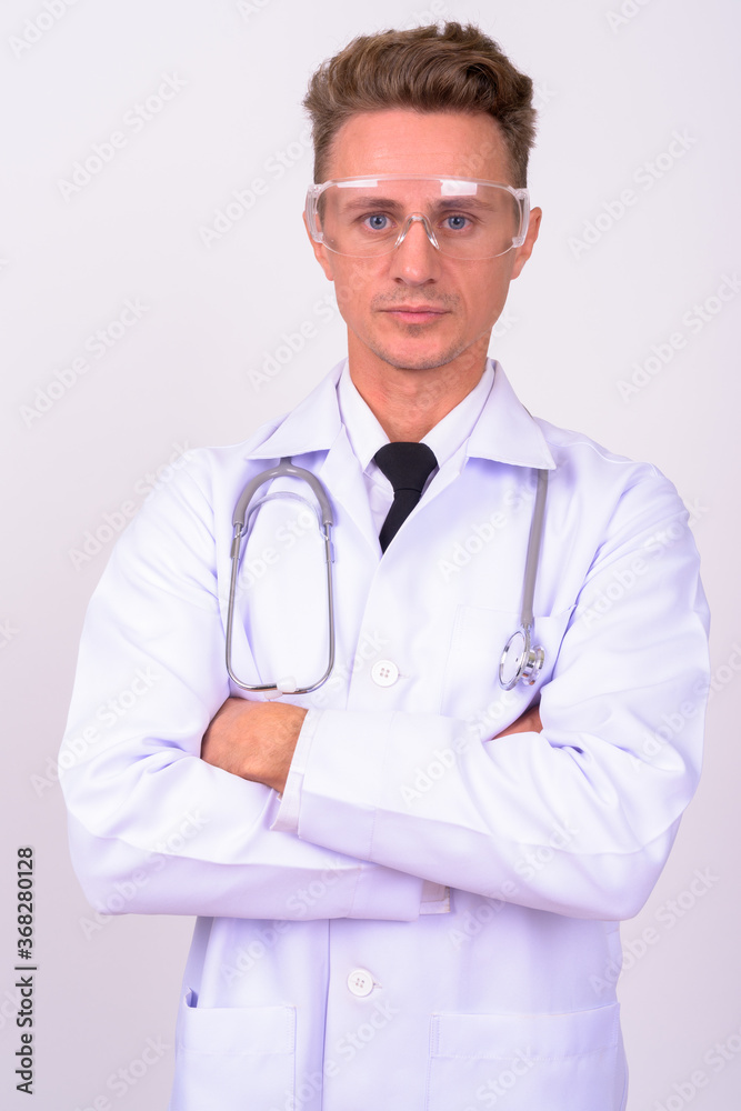 Handsome man doctor with blond curly hair wearing protective glasses against white background Handsome man doctor with blond curly hair wearing protective glasses against white background