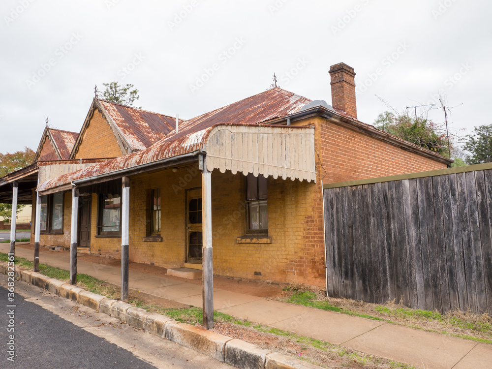 Very old building with awning and rusted roof on an overcast day