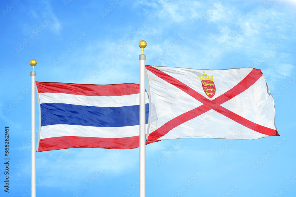 Thailand and Jersey two flags on flagpoles and blue sky