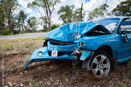 Red P1 license plate on wrecked blue car photo