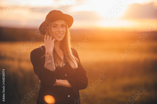 Blonde junge Frau bei Sonnenuntergang im Gegenlicht.