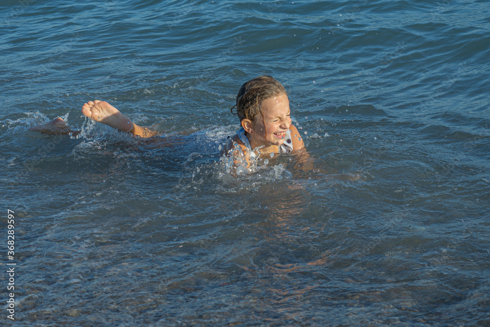 Soft focus. Little girl swim in the mediterranean sea. High quality photo