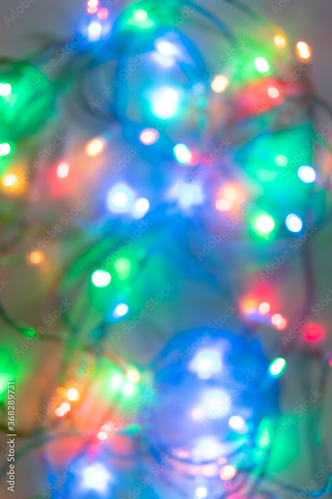 Festive Christmas blurred background of bright glowing colored garland.