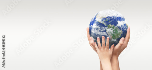 Fototapeta Naklejka Na Ścianę i Meble -  Earth globe in family hands. World environment day. Elements of this image furnished by NASA