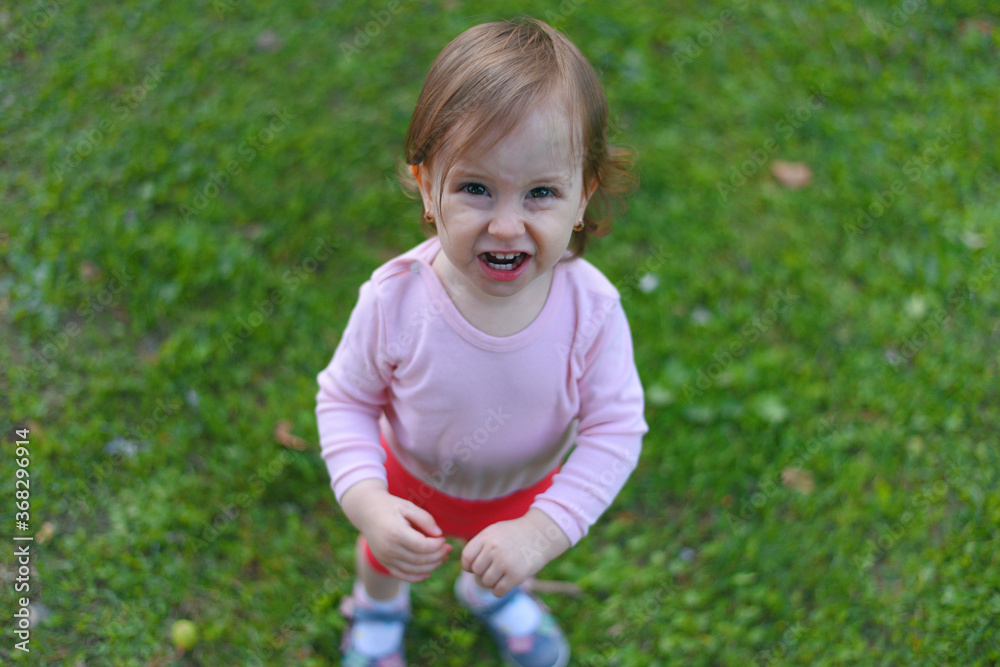 Adorable happy baby girl having fun in park grass, playing in the summer park. Adorable happy baby girl having fun in park grass, playing in the summer park.