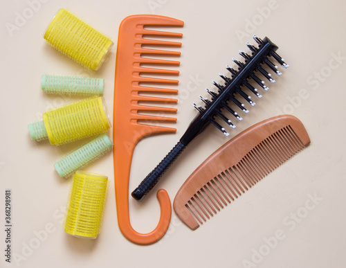 Green yellow curlers  combs  hair brush. Hair care concept. Pastel background. Top view