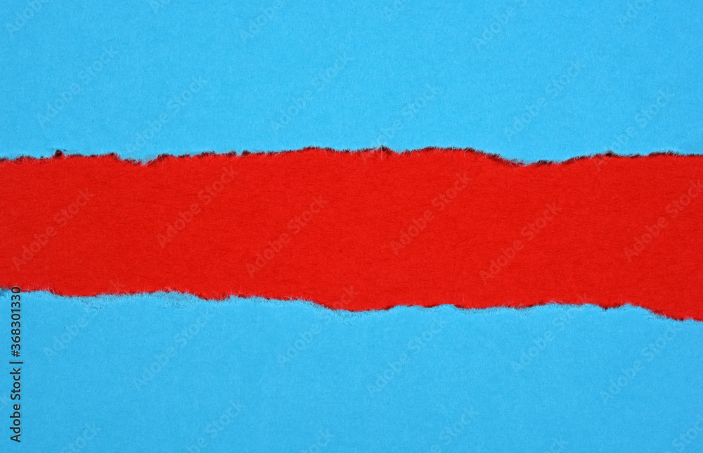 Ripped in blue paper on red background Ripped in blue paper on red background