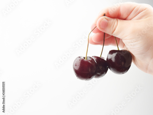 child holding a cherry © ALEXANDER