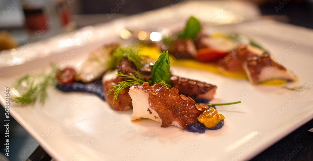 Selective focus on the octopus salad plate. Concept of Mediterranean cuisine, healthy and tasty Selective focus on the octopus salad plate. Concept of Mediterranean cuisine, healthy and tasty