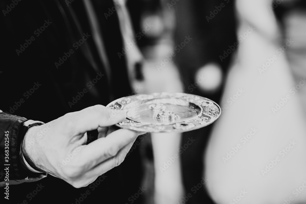 Fototapeta premium Wedding rings on ceremony at church. Macro.