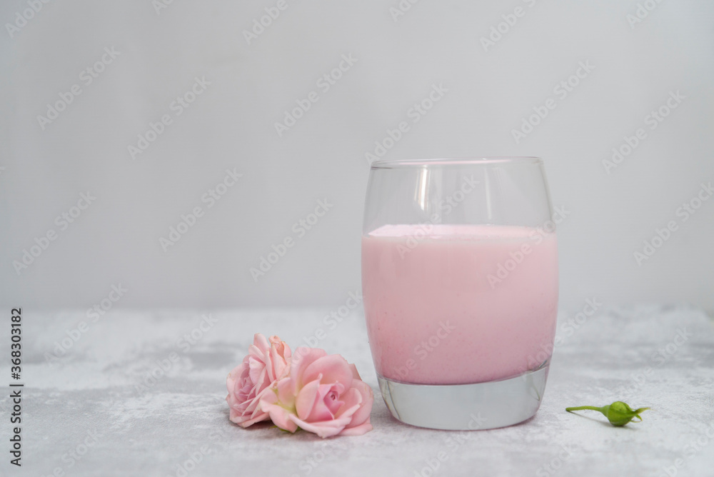 glass of pink milk with pink flowers. glass of pink milk with pink flowers.
