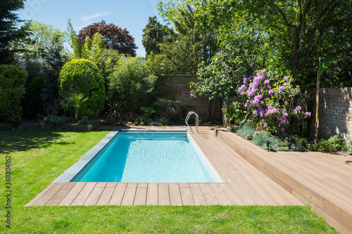 Sunny idyllic swimming pool and summer garden photo