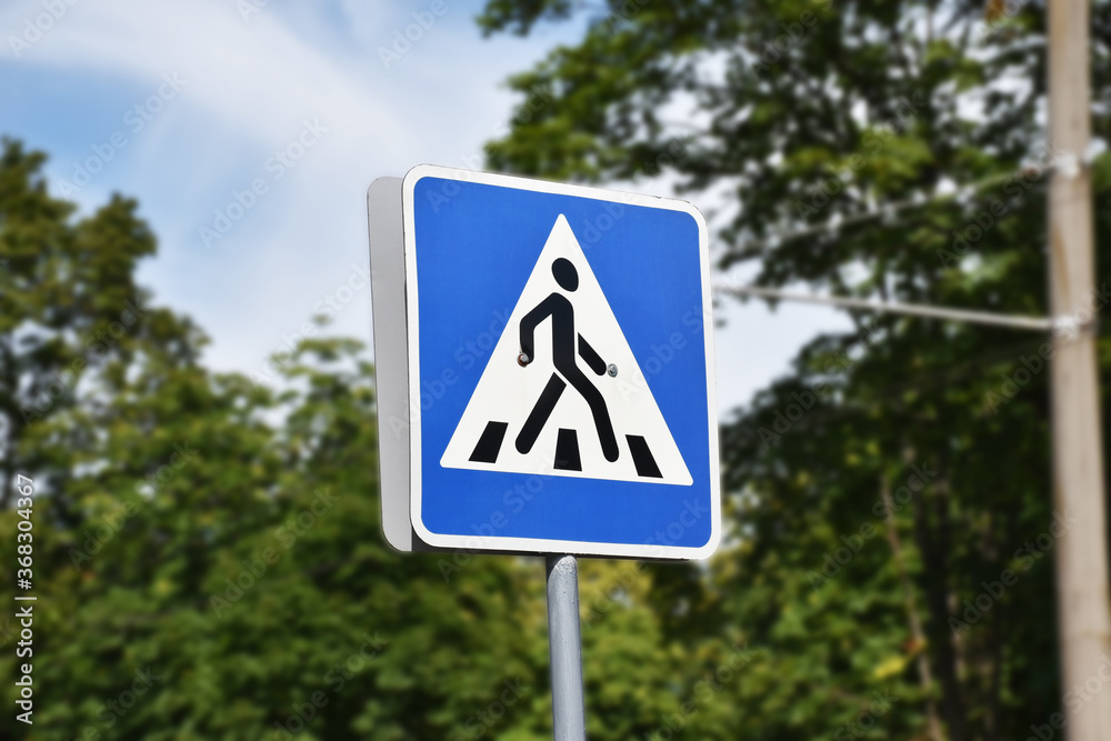 Pedestrian sign crossing through street. Road sign of safety