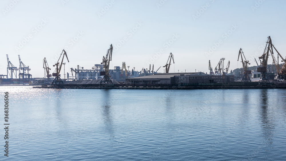 Odessa, Ukraine - August 15, 2016: Container cranes in cargo port terminal, cargo cranes without job in an empty harbor port. 