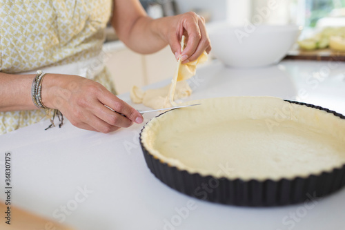 Close up woman cutting edge of pie crust photo
