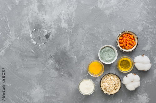 Natural ingredients for homemade cosmetic masks on a gray concrete background. The concept of beauty and rejuvenation. Top view, flat lay, copy space.