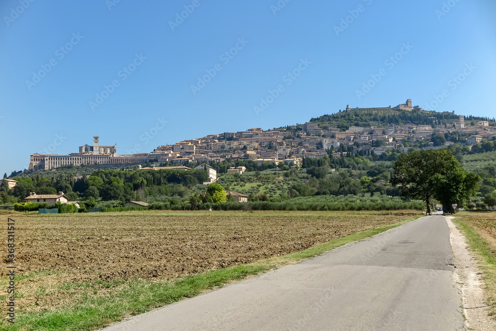 General view, from the road, of the city of Assisi, with the Basilica of St. Francis of Assisi on the left and the Rocca Maggiore castle on the top, Umbria region, Perugia province, Italy