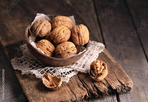 Walnuts in a basket on a wooden table.