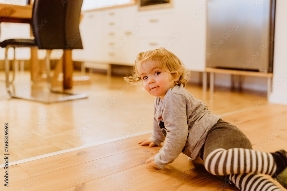 Toddler playing on floor in kitchen