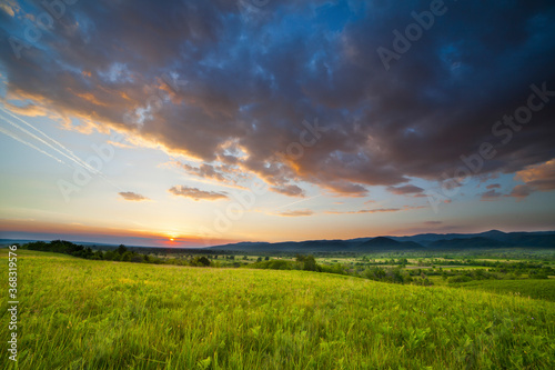 Dramatic sunset over green field