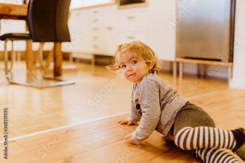 Toddler playing on floor in kitchen