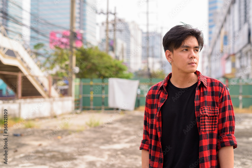 Young handsome Asian hipster man in the city streets outdoors Young handsome Asian hipster man in the city streets outdoors