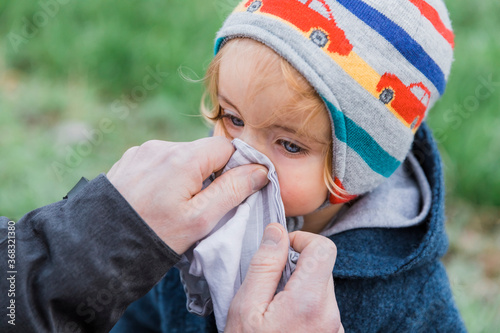 Tablou pe pânză Man wiping toddler’s nose