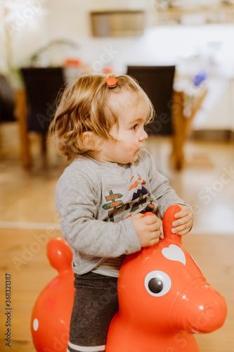 Toddler riding on toy horse photo