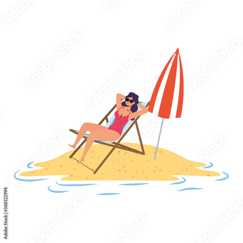 young woman relaxing on the beach seated in chair and umbrella
