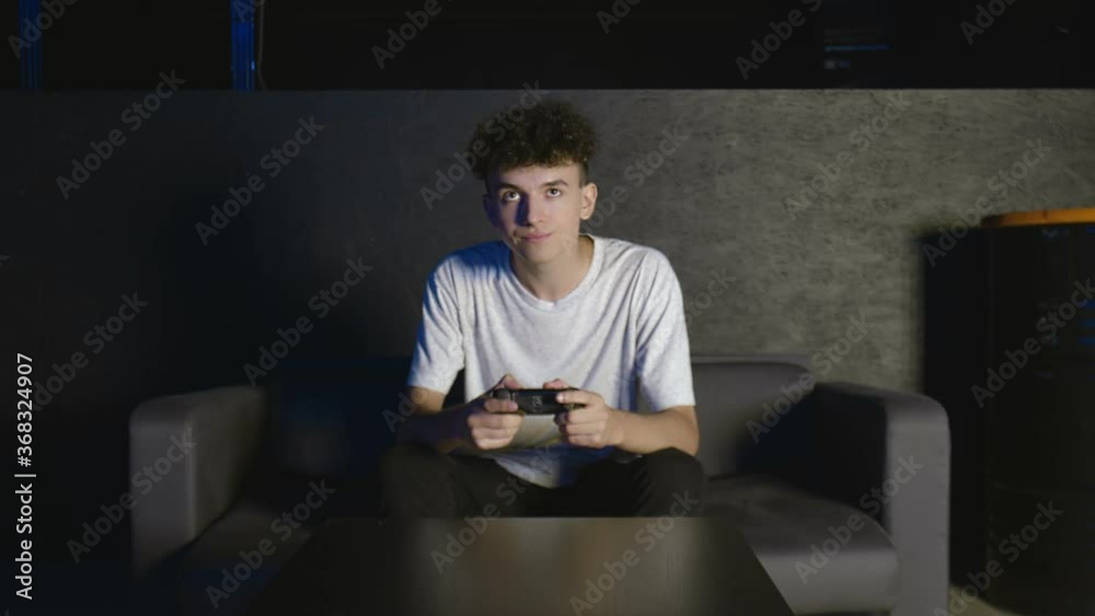 Upset schoolboy losing in video game and hitting his knee. Hard Game Upset schoolboy losing in video game and hitting his knee. Hard Game