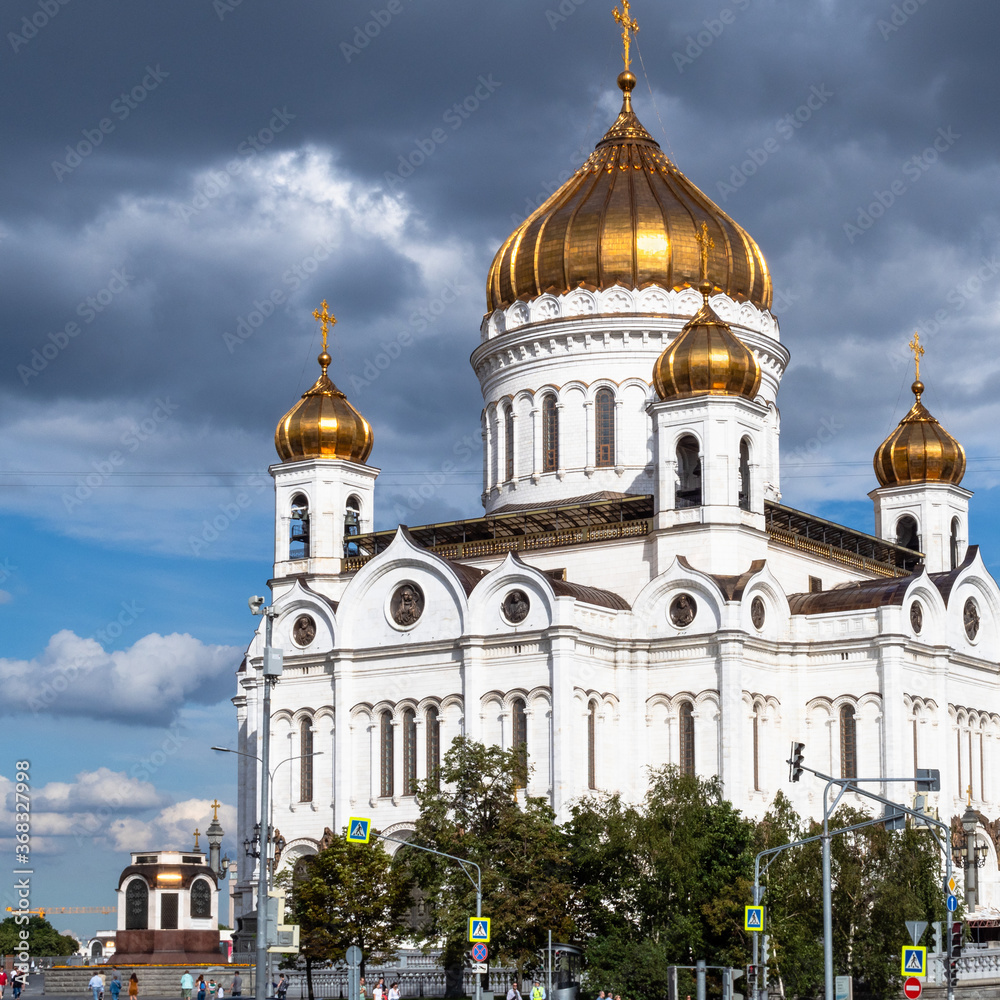 view of Cathedral of Christ the Saviour under dark gray rainy clouds in Moscow city in sunny summer evening