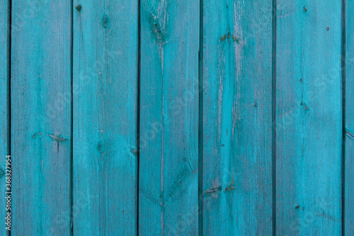 Wooden old vintage fence painted with turquoise paint. Abstract background made of texture boards.